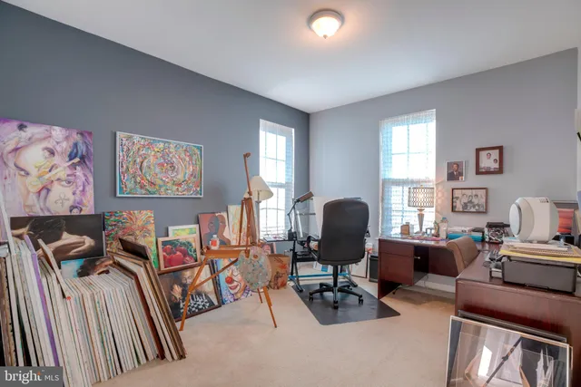 a view of a livingroom with workspace and a window