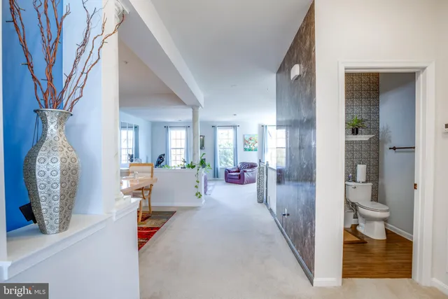 a hallway with a dining table and a chandelier