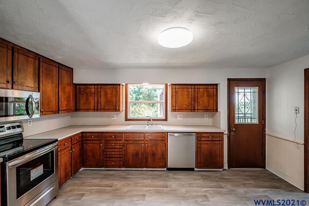 1278 Southwest Maple Street Dallas, OR 97338 - Photo 15 of 42 a kitchen with stainless steel appliances granite countertop a stove sink and cabinets