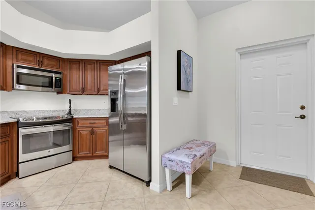 a kitchen with stainless steel appliances kitchen island granite countertop a refrigerator stove and sink