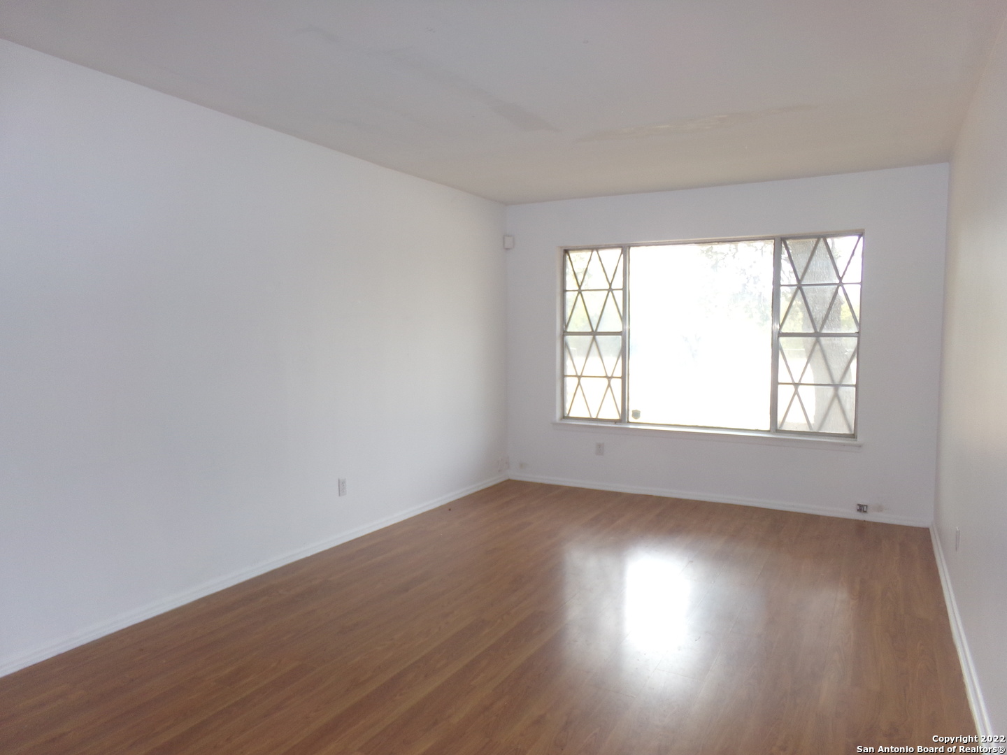 5975 Babcock Road San Antonio, TX 78240 - Photo 11 of 29 an empty room with wooden floor and windows