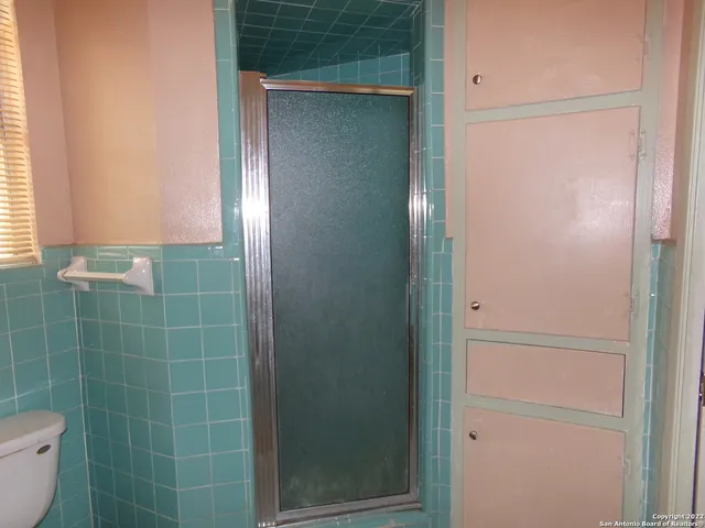 a bathroom with a toilet and a shower