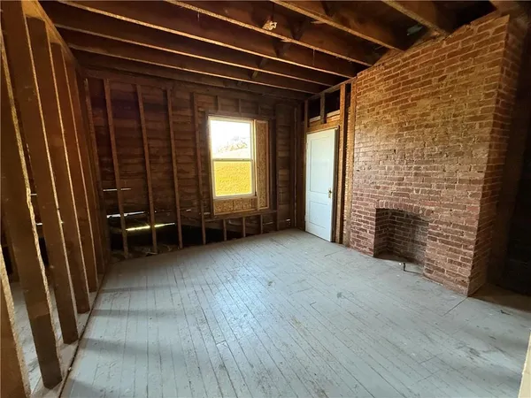 a view of a livingroom with wooden floor and a fireplace