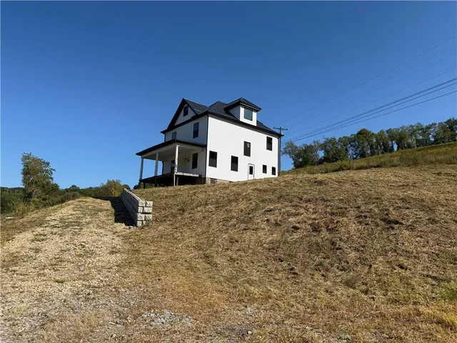 a white house that has a big yard with wooden fence