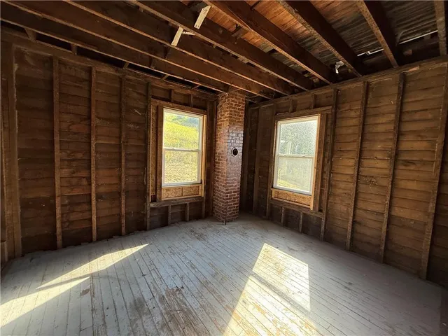 a view of a hallway with wooden floor and a fireplace