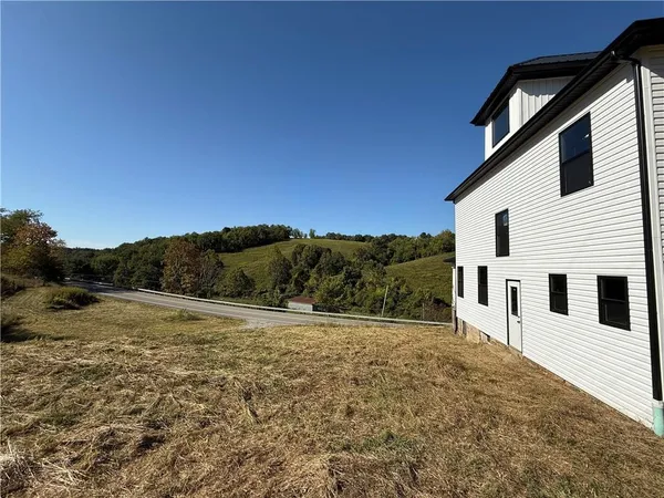 a view of a large white house with a yard
