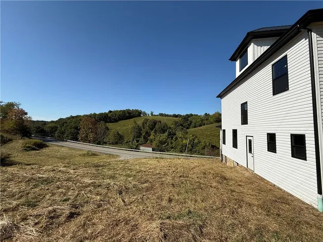 a view of a large white house with a yard