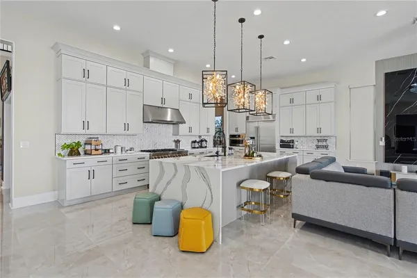 a large white kitchen with white cabinets and stainless steel appliances