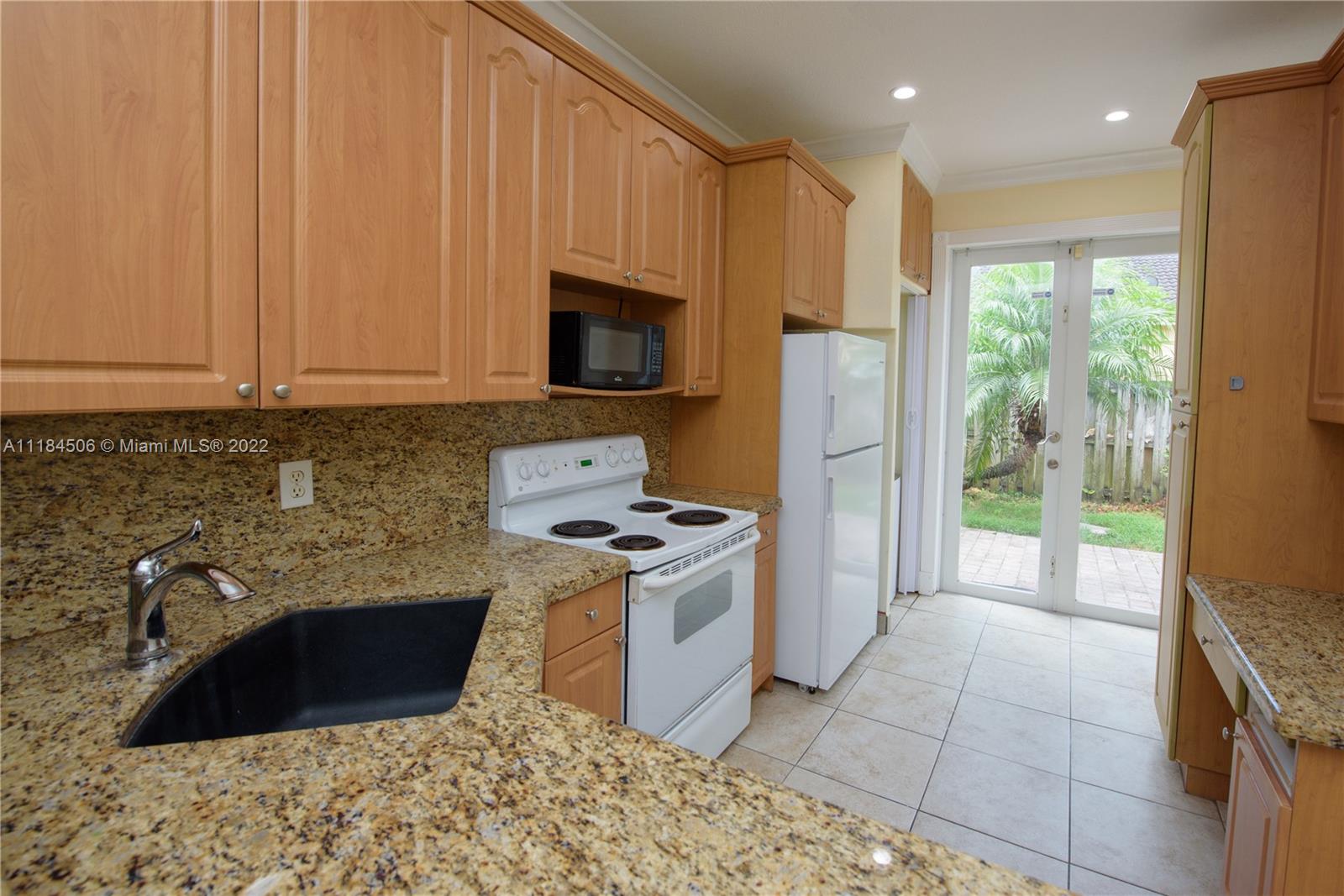 94 Southwest 15th Road Homestead, FL 33030 - Photo 3 of 15 a kitchen with stainless steel appliances granite countertop a stove a sink and a refrigerator