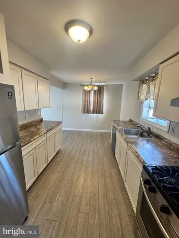 a kitchen with wooden floors and appliances