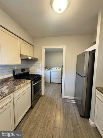 a kitchen with a refrigerator and a stove top oven