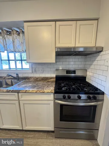 a stove top oven sitting inside of a kitchen