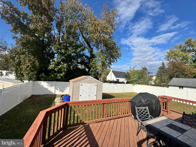 a view of a roof deck with couches and wooden fence
