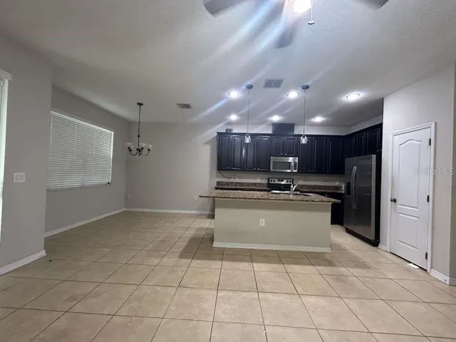 a large kitchen with a large counter top stainless steel appliances and cabinets