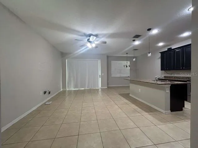 a view of kitchen with granite countertop cabinets and window