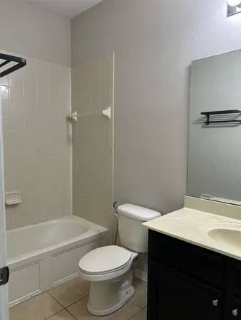 a white toilet sitting next to a bath tub