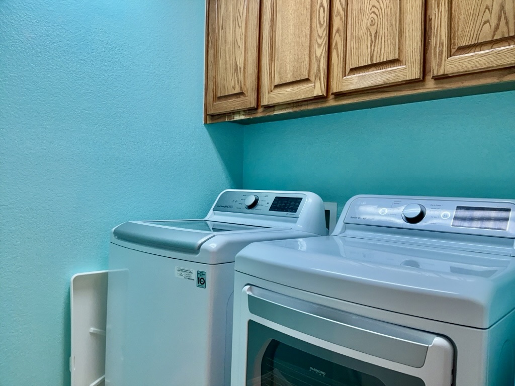 2518 Vestavia Ridge Lane Cedar Park, TX 78613 - Photo 20 of 23 Laundry room featuring a textured wall, cabinet space, and washer and clothes dryer