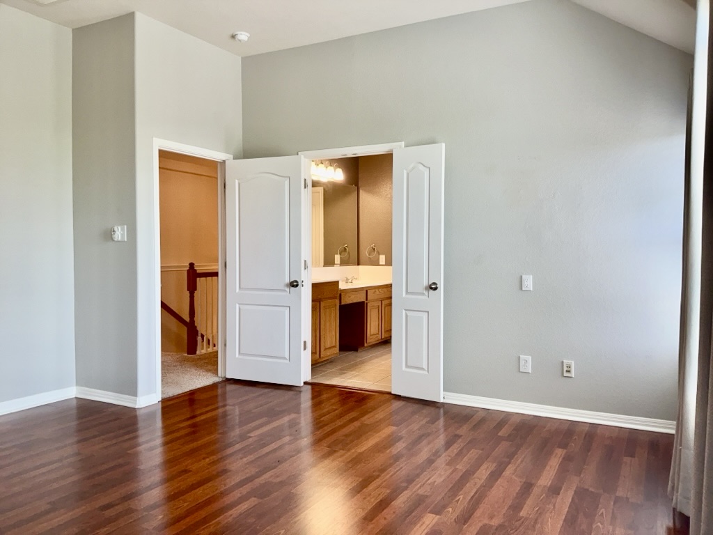 2518 Vestavia Ridge Lane Cedar Park, TX 78613 - Photo 9 of 23 Primary Bedroom featuring dark wood-style floors, vaulted ceiling, and connected bathroom