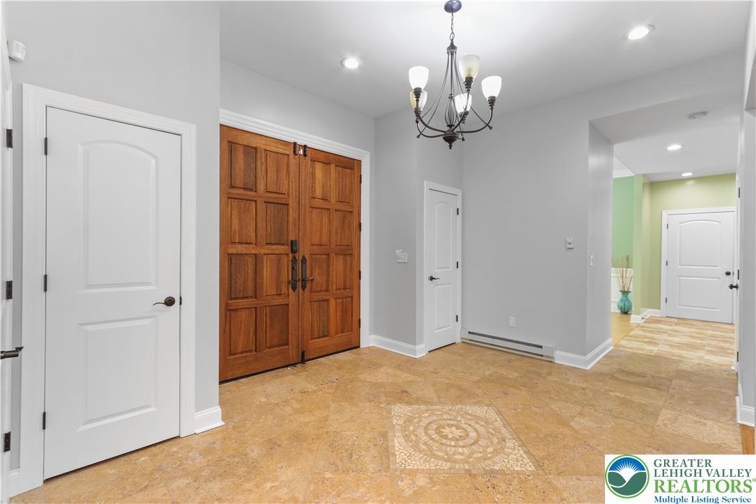 1007 Hampstead Road Bushkill, PA 18324 - Photo 2 of 72 Enter through grand double doors into a welcoming foyer with elegant tiled flooring and a sophisticated overhead chandelier.