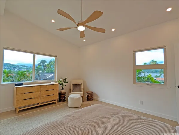 an empty room with windows and ceiling fan