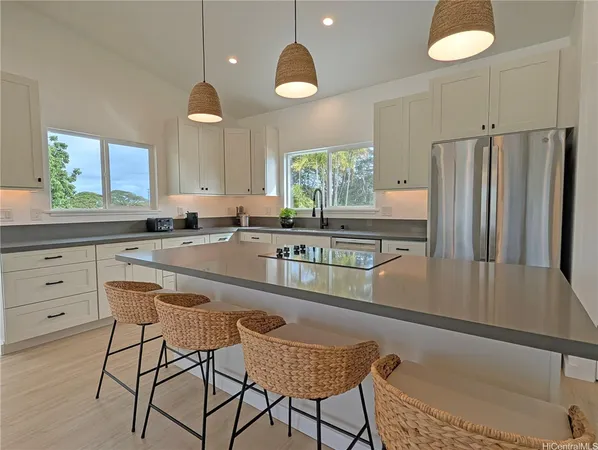 a kitchen with granite countertop a refrigerator and white cabinets