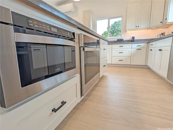 a kitchen with stainless steel appliances cabinets and a window