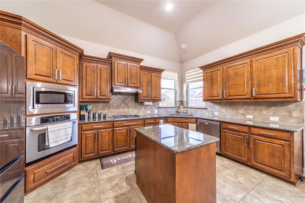 720 Nighthawk Drive Murphy, TX 75094 - Photo 14 of 40 a kitchen with stainless steel appliances granite countertop wooden cabinets a sink and dishwasher a stove top oven with wooden floor