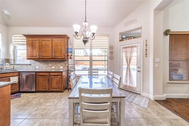 a view of a kitchen with granite countertop a refrigerator stove top oven and sink
