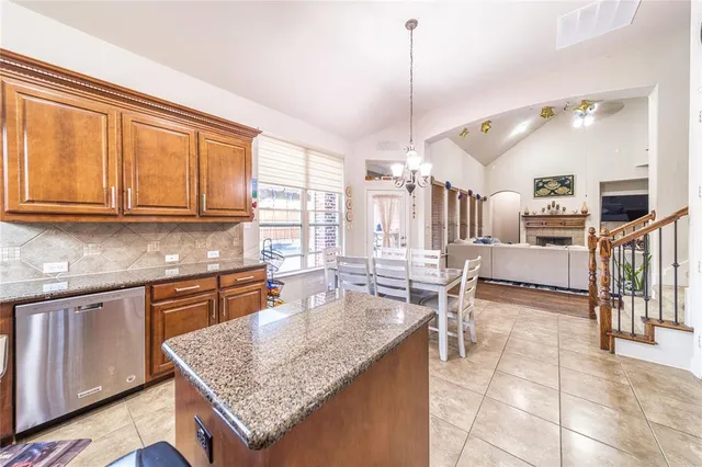 a kitchen with stainless steel appliances granite countertop a stove top oven a sink dishwasher and cabinets with wooden floor