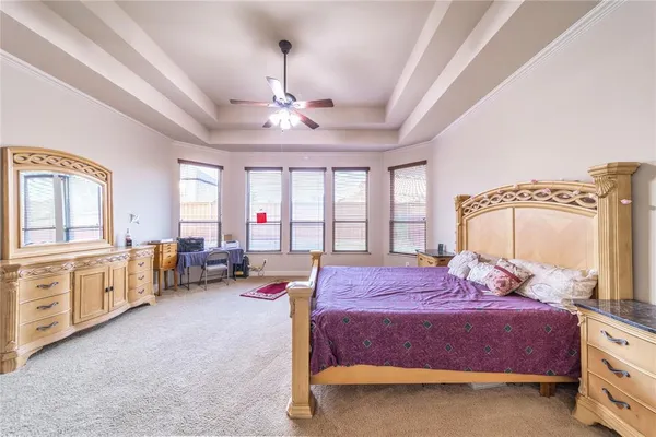 a spacious bedroom with a large bed and a chandelier