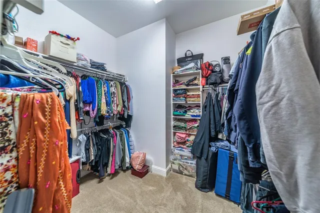 a view of walk in closet with clothes