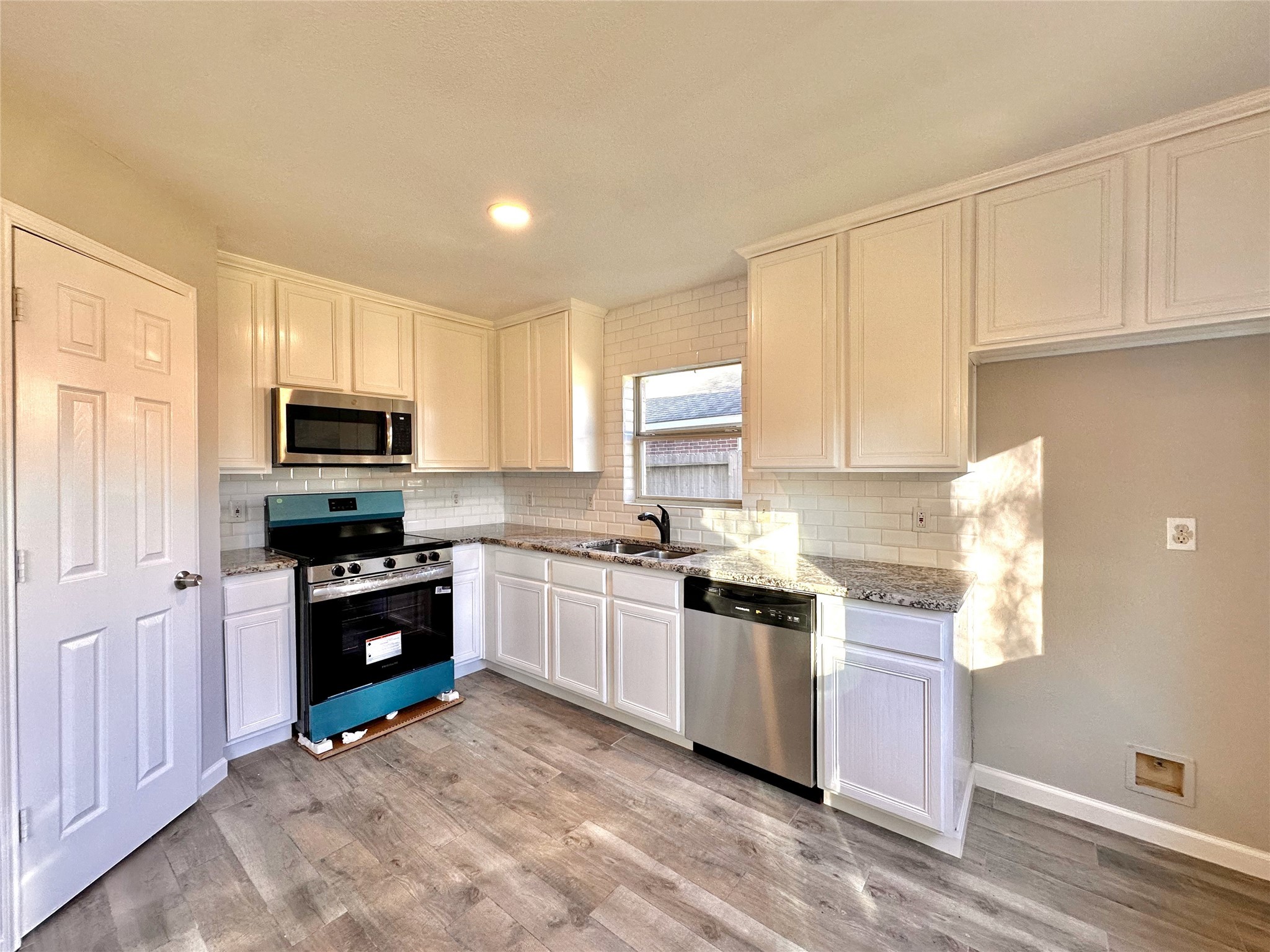 3042 Trinity Pass Court Spring, TX 77373 - Photo 15 of 34 a kitchen with stainless steel appliances granite countertop a stove top oven a sink dishwasher and a refrigerator with wooden floor