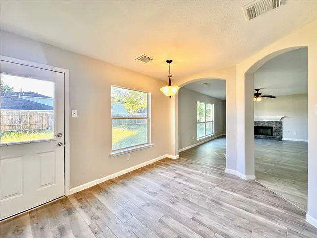 a view of a livingroom with wooden floor and a ceiling fan