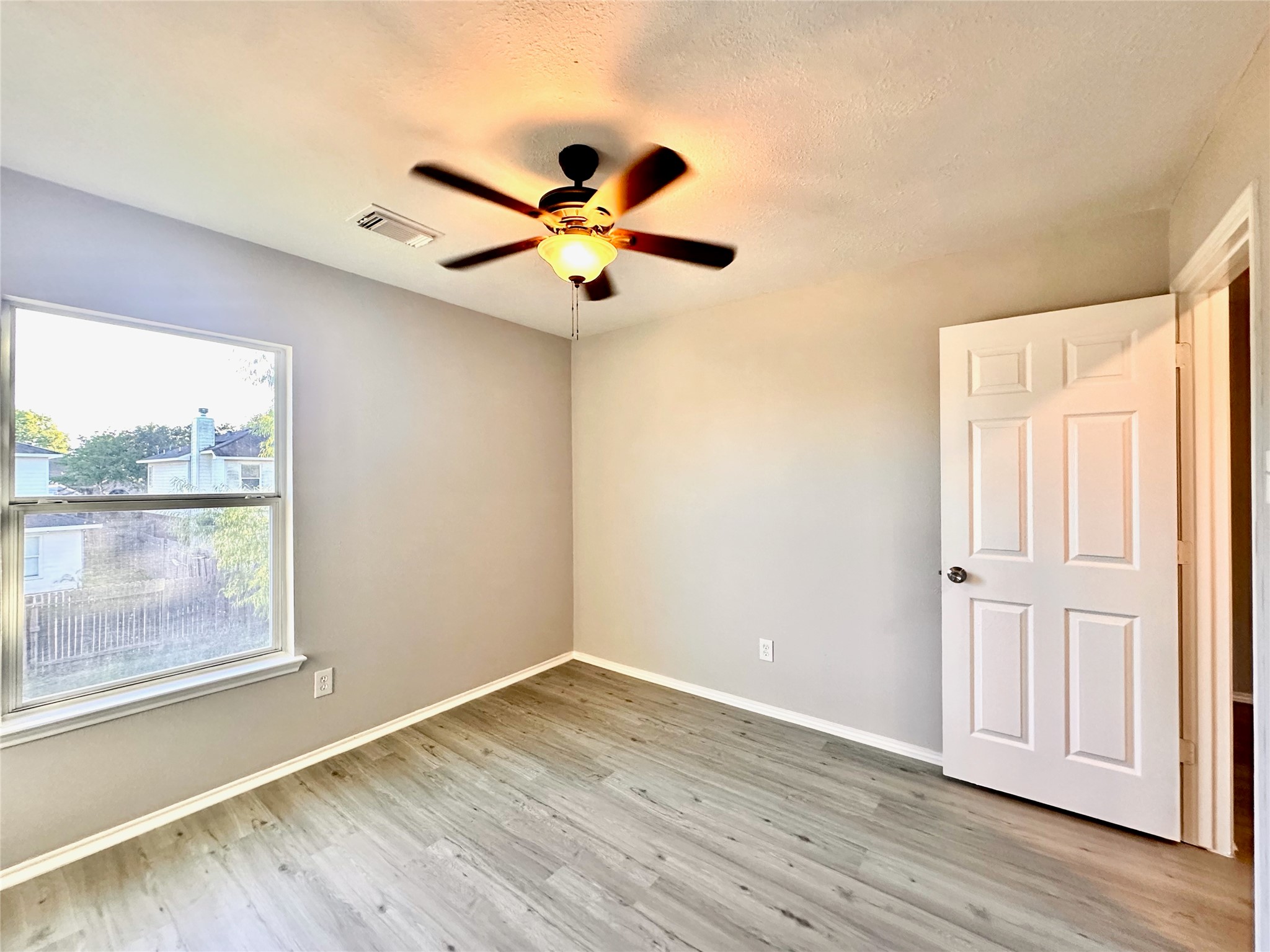 3042 Trinity Pass Court Spring, TX 77373 - Photo 25 of 34 an empty room with wooden floor fan and windows