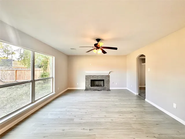 a view of an empty room with a fireplace and a window
