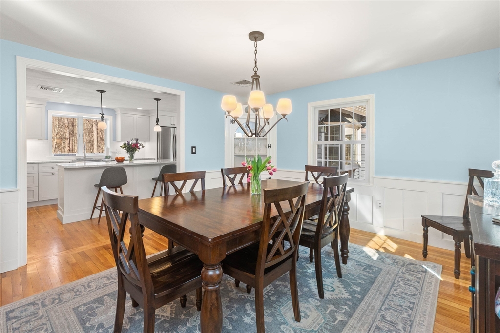 27 Sheffield Road Boxford, MA 01921 - Photo 7 of 29 a dining room with wooden floor a chandelier a wooden table and chairs