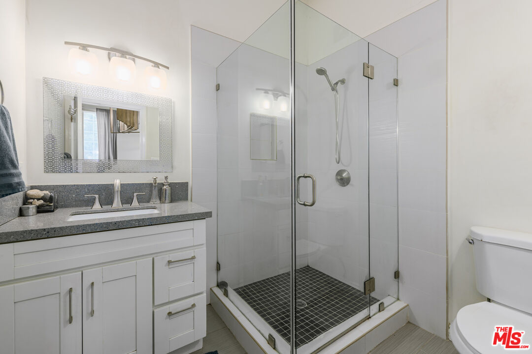 2225 North Cahuenga Boulevard Los Angeles, CA 90068 - Photo 20 of 30 a bathroom with a granite countertop sink a mirror and a shower