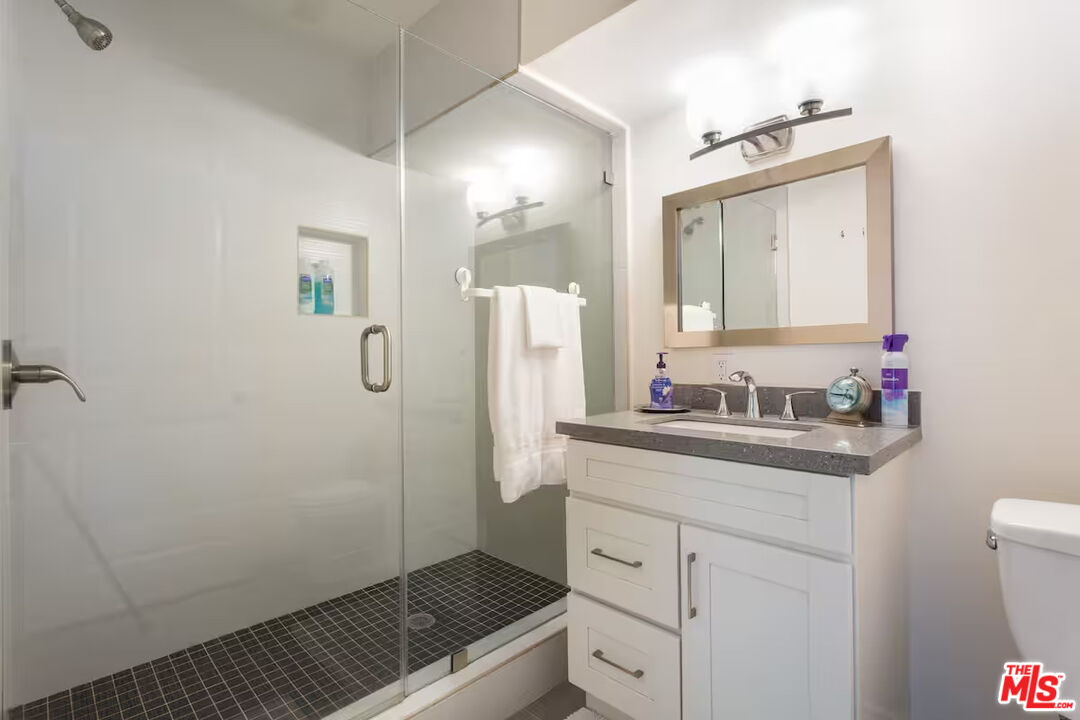2225 North Cahuenga Boulevard Los Angeles, CA 90068 - Photo 26 of 30 a bathroom with a granite countertop sink a mirror and a shower