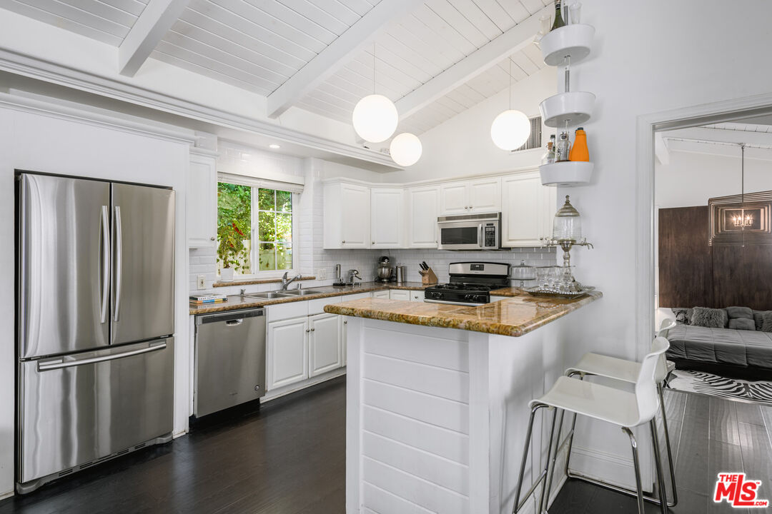 2225 North Cahuenga Boulevard Los Angeles, CA 90068 - Photo 9 of 30 a kitchen with stainless steel appliances granite countertop a refrigerator a stove a sink and a microwave