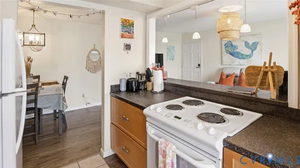 a kitchen with a stove a refrigerator and a dining table with wooden floor