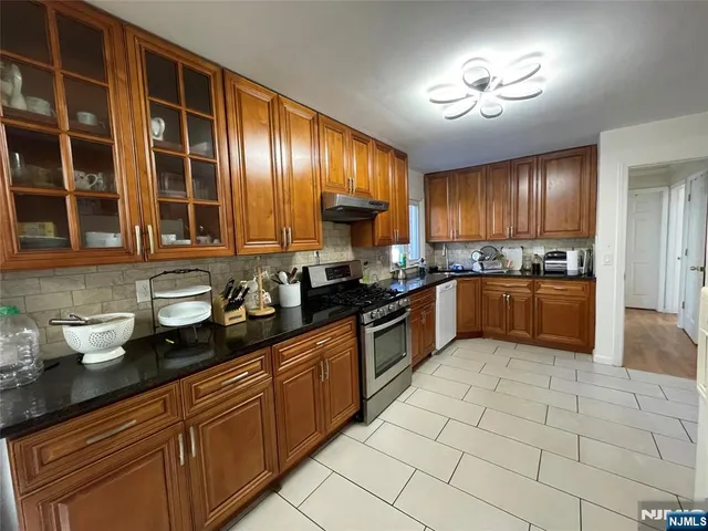 a kitchen with stainless steel appliances granite countertop a stove sink and cabinets