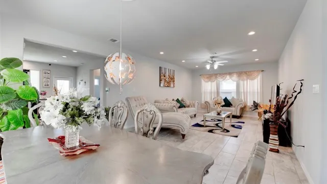a living room with furniture flowers and a chandelier