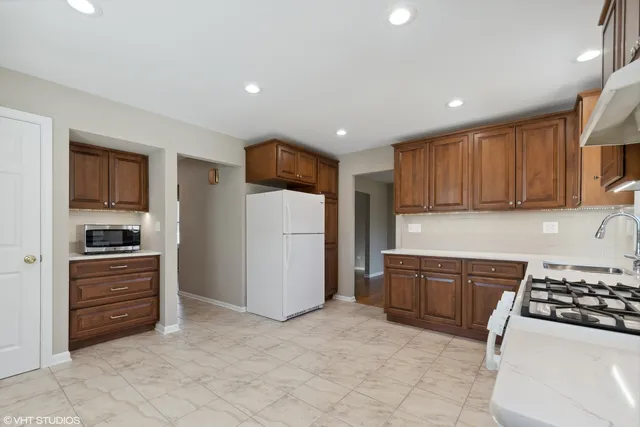 a kitchen with stainless steel appliances granite countertop a refrigerator and a stove top oven