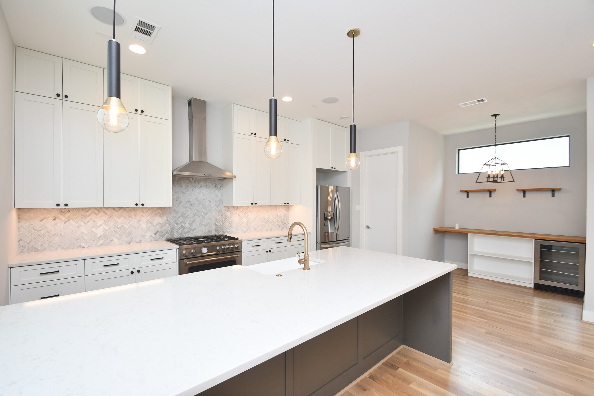 818 Knox Street Houston, TX 77007 - Photo 15 of 39 a kitchen with stainless steel appliances a stove a sink a refrigerator a center island and wooden floor