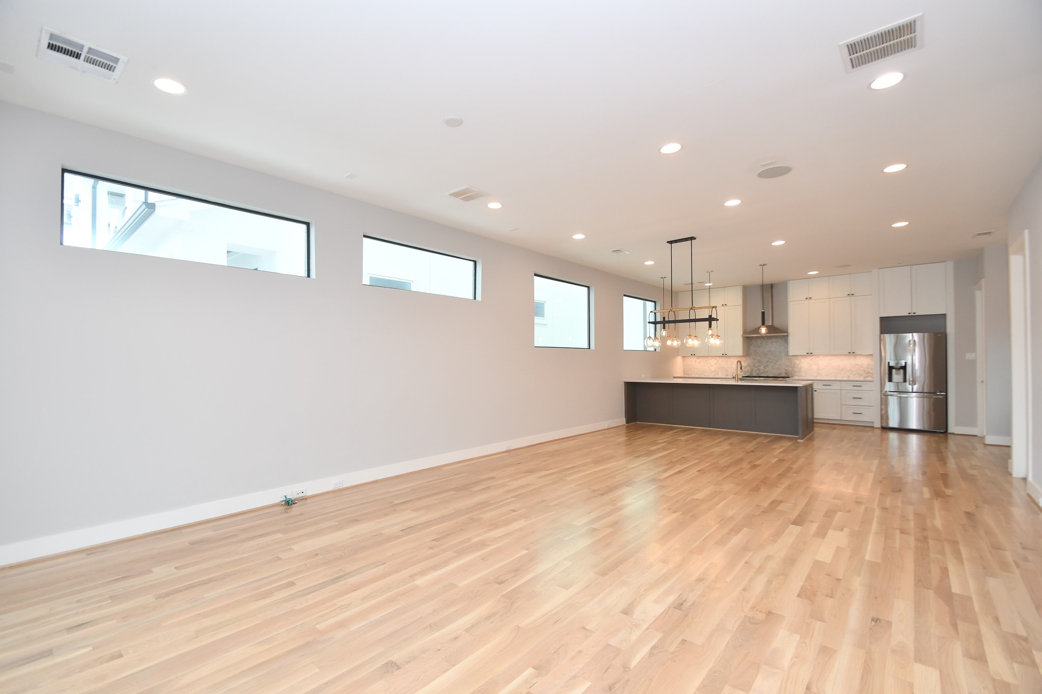 818 Knox Street Houston, TX 77007 - Photo 8 of 39 a view of kitchen and empty room with wooden floor