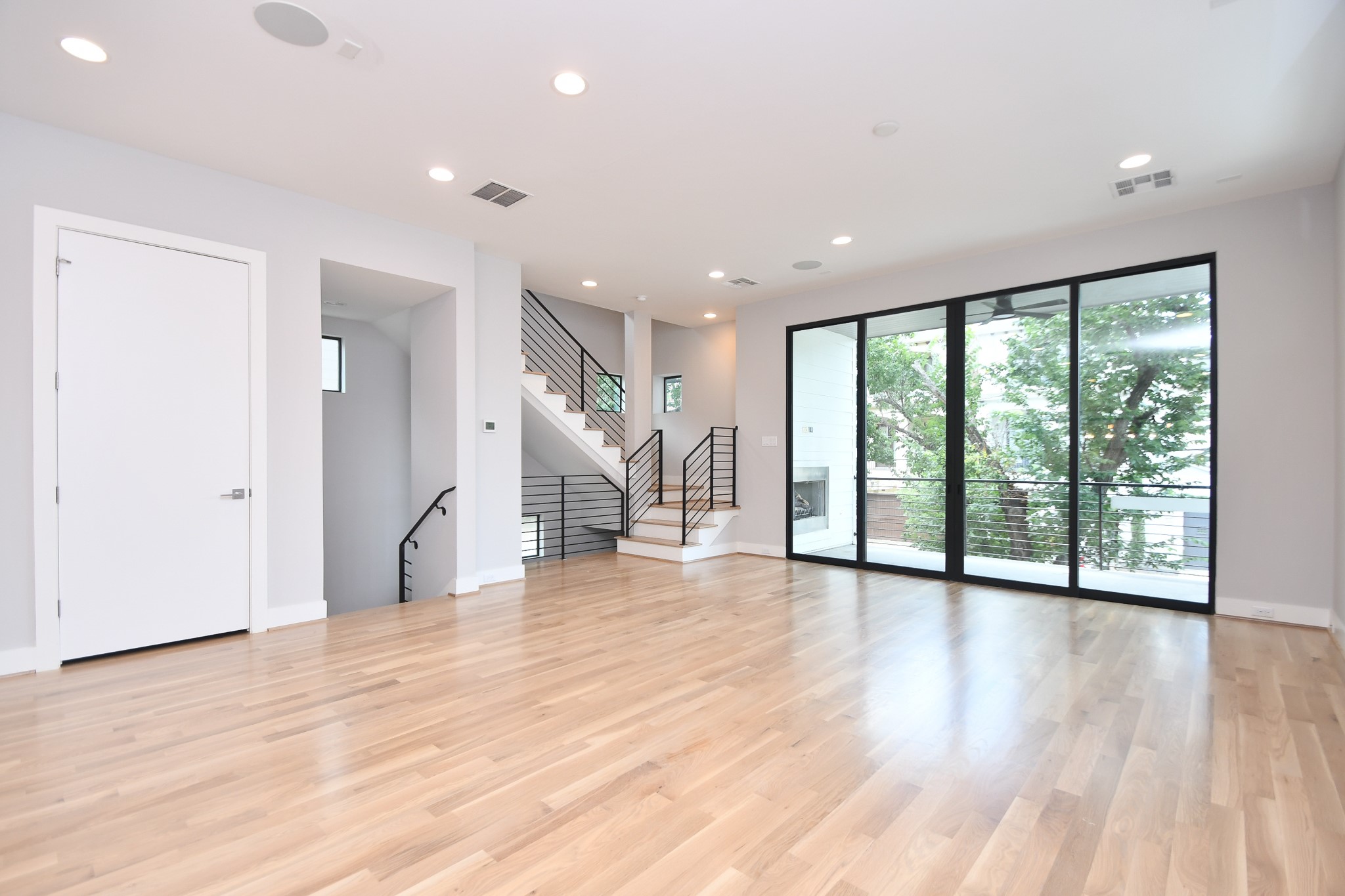 818 Knox Street Houston, TX 77007 - Photo 9 of 39 a view of an empty room with wooden floor and a window