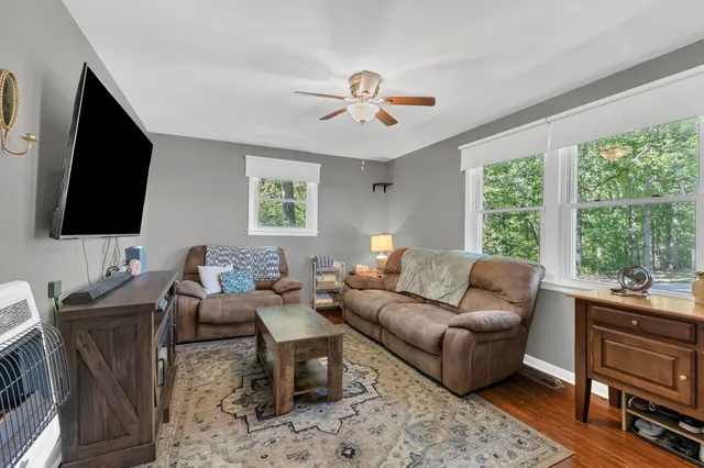 a living room with furniture a flat screen tv and a large window