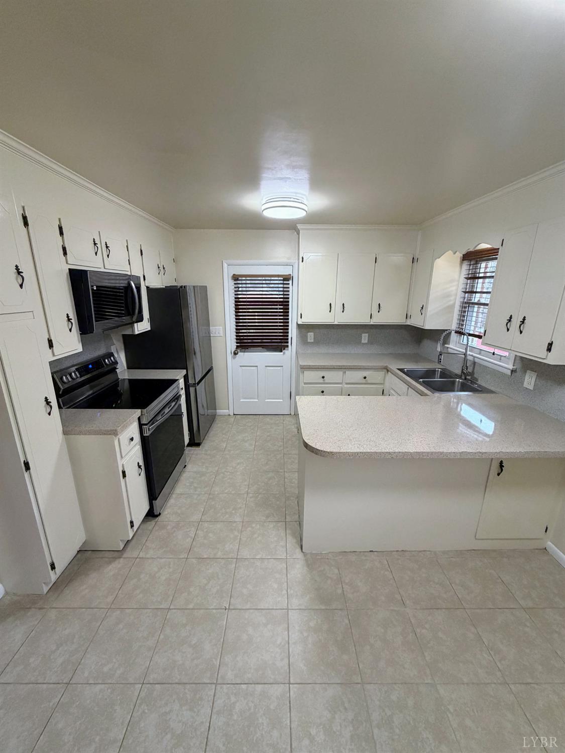106 Bryant Road Lynchburg, VA 24502 - Photo 4 of 39 a kitchen with stainless steel appliances a stove a sink a microwave a refrigerator and cabinets