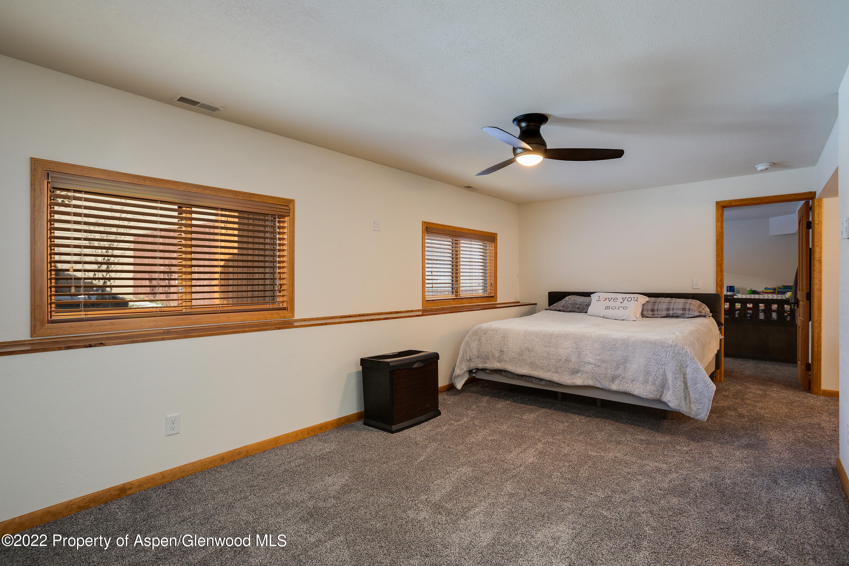 328 Little Bend Road Hayden, CO 81639 - Photo 20 of 27 a spacious bedroom with a bed and a chandelier
