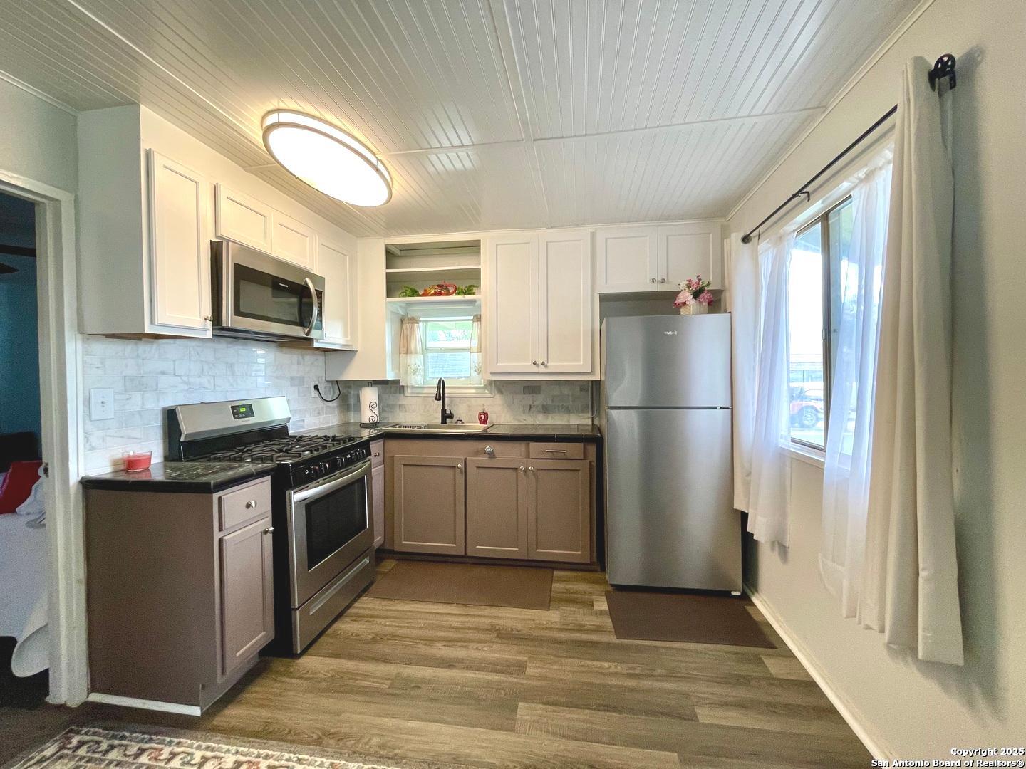 406 Hackberry Street Bandera, TX 78003 - Photo 13 of 34 a kitchen with a refrigerator stove top oven and sink